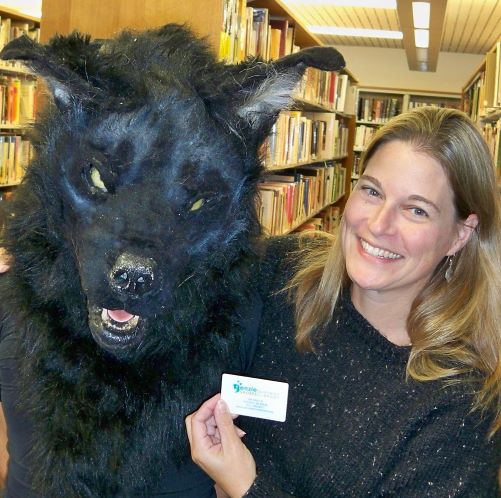 the Michigan Dogman gets a library card from the library director.